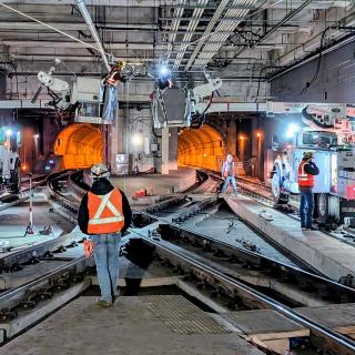 Workers perform construction work in the Seattle transit tunnel.