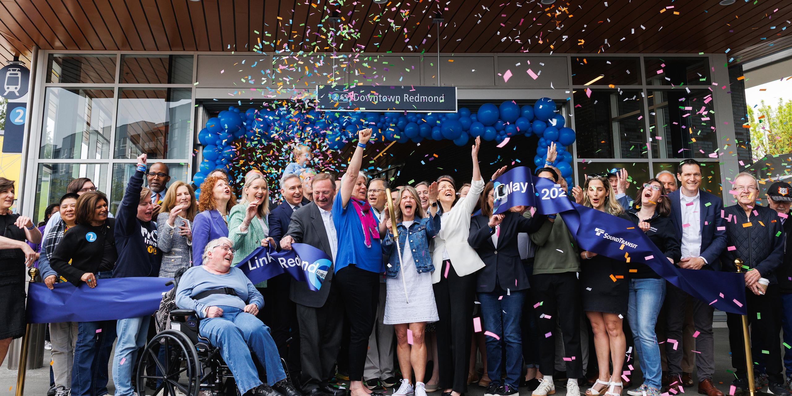 People gathered at the ribbon cutting for Downtown Redmond Link Extension celebrate as confetti falls.