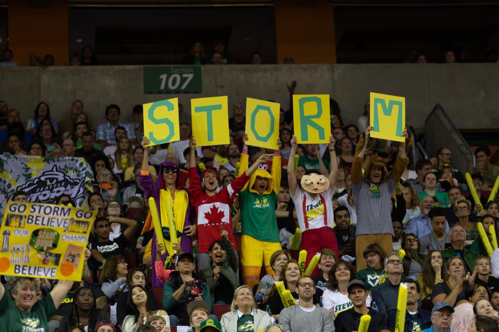 Image of fans holding up signs at a Seattle Storm game