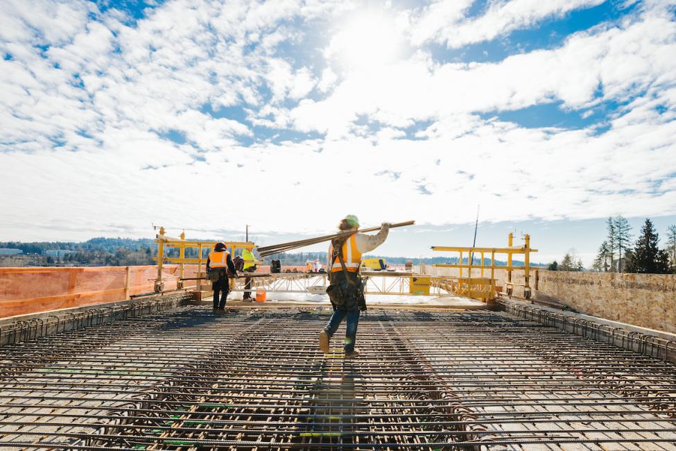 A construction worker carries lumber across the future platform at the future South Bellevue Station site.