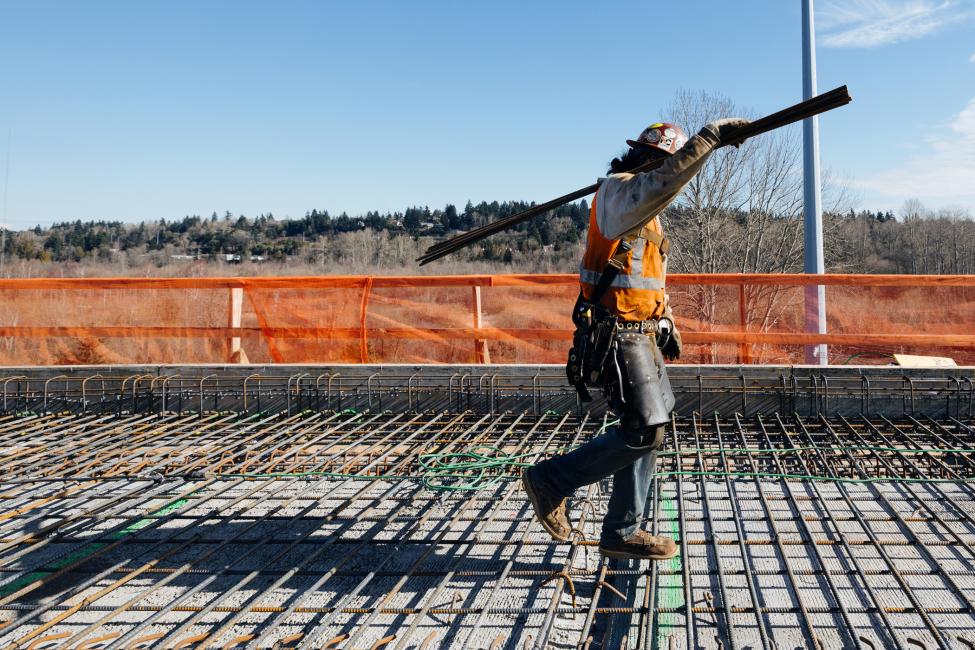 Construction worker walks across rebar.