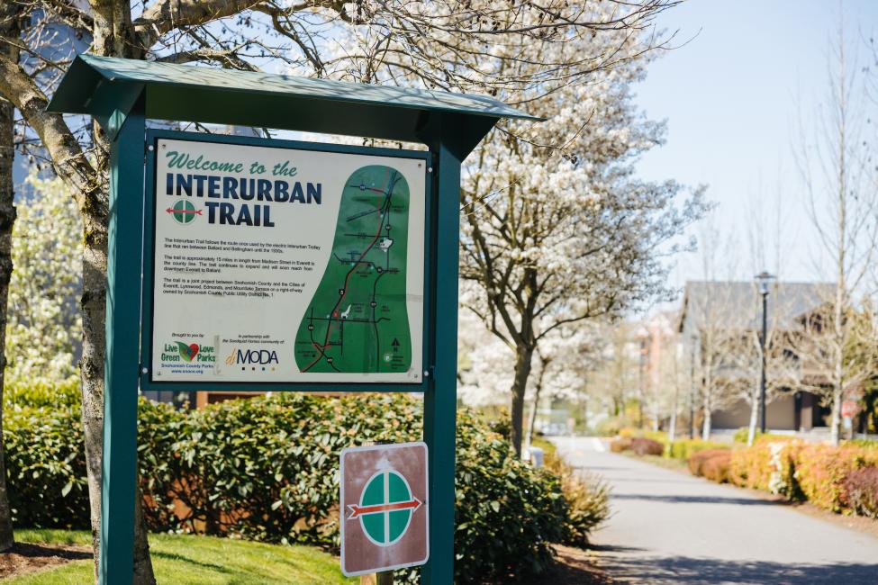 A colorful sign provides information on the Interurban Trail.