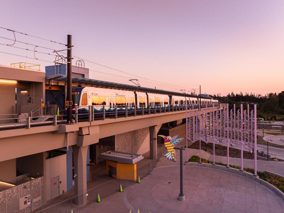 The sky takes on a pink and purple glow behind the elevated Lynnwood City Center Station