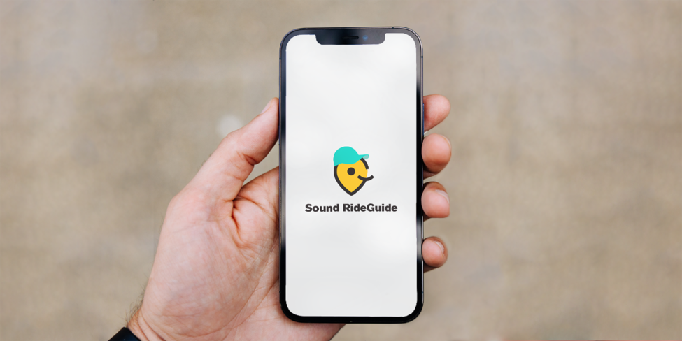 Person holding phone with Sound RideGuide logo