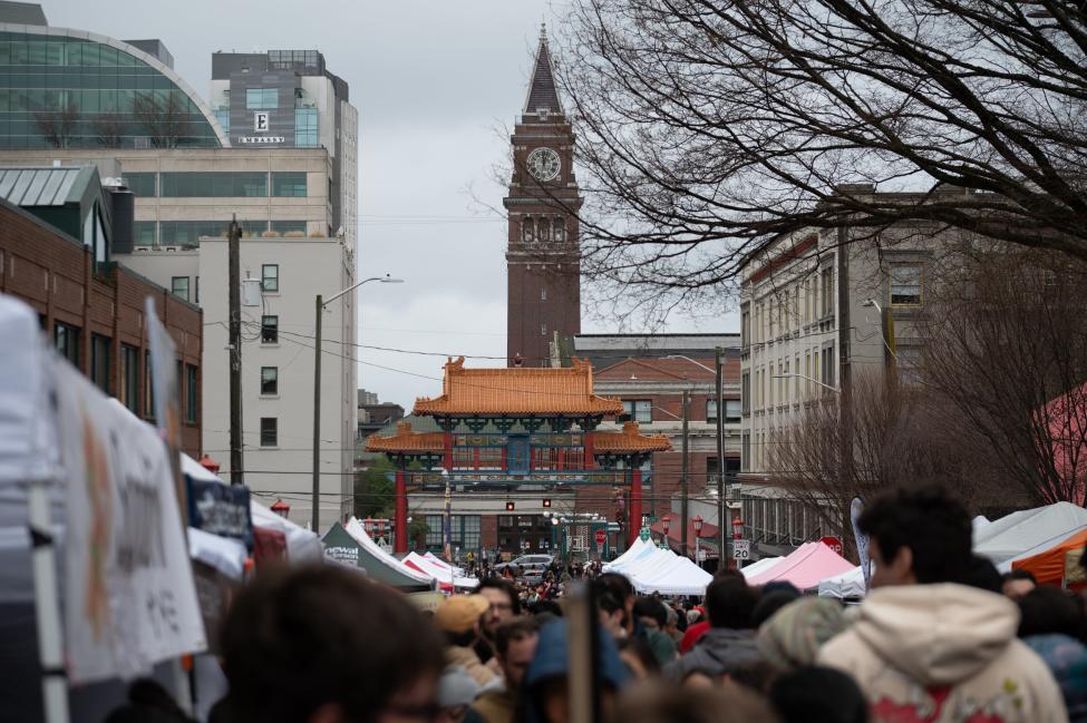 The gate to Seattle's Chinatown-International District is seen in the distance over the heads of a large crowd celebrating Lunar New Year