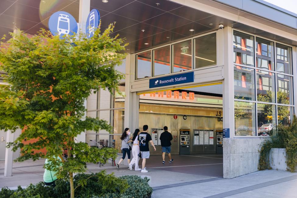 Passengers pass through the entrance of Roosevelt Station on a summer day