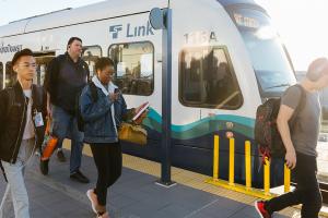 Riders board and exit a Link light rail train.