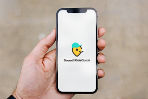 Person holding phone with Sound RideGuide logo