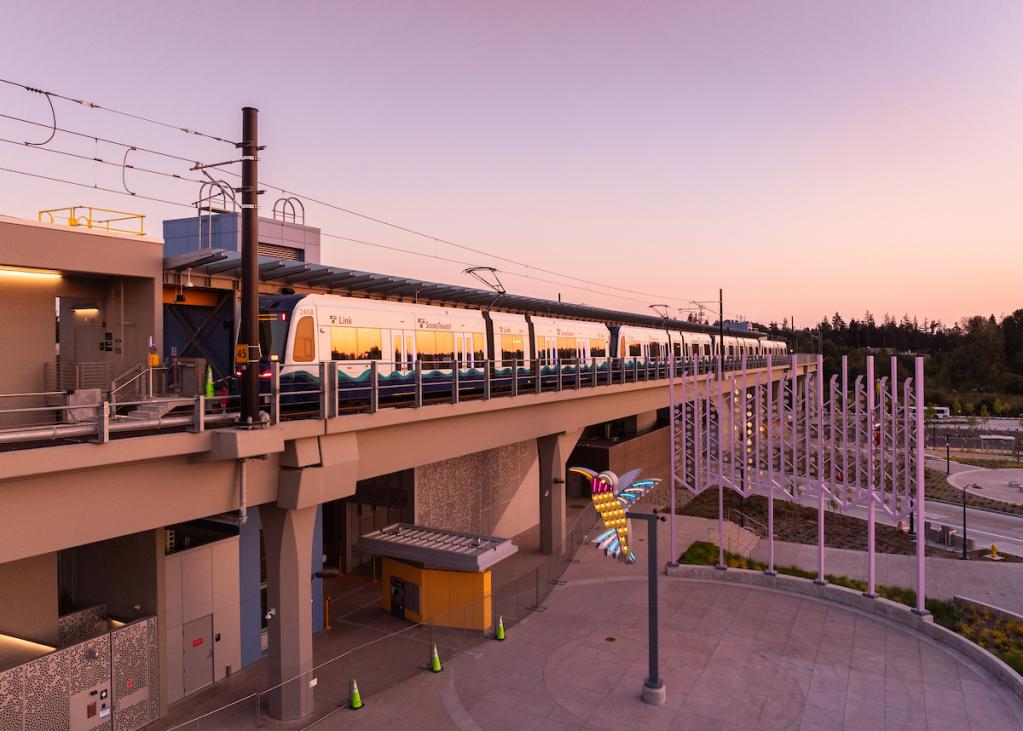 The sky takes on a pink and purple glow behind the elevated Lynnwood City Center Station