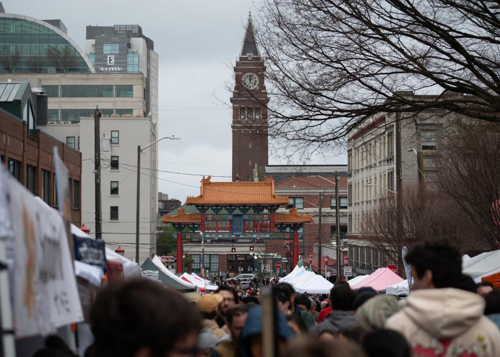 The gate to Seattle's Chinatown-International District is seen in the distance over the heads of a large crowd celebrating Lunar New Year