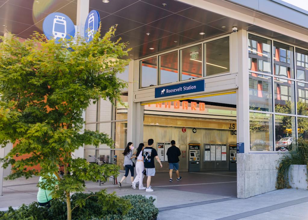 Passengers pass through the entrance of Roosevelt Station on a summer day